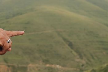 Een vinger wijst over een natuurlandschap