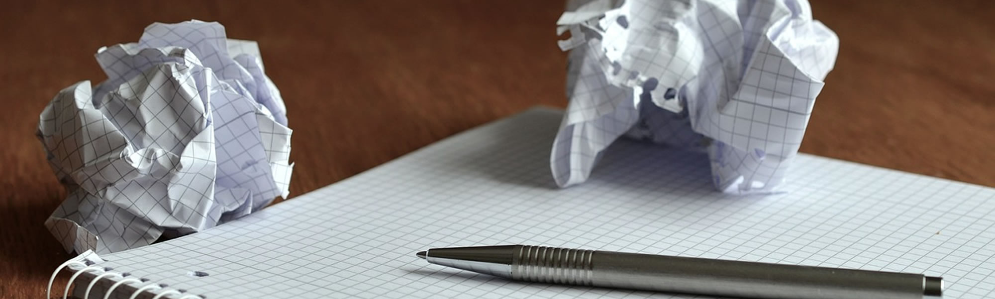 Pen op ruitjespapier en twee papierproppen