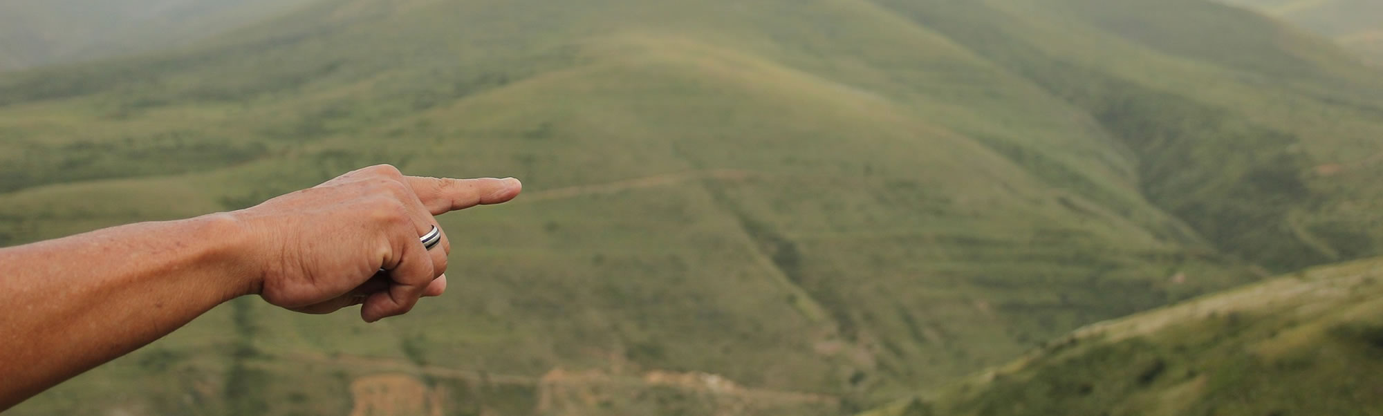 Een vinger wijst over een natuurlandschap